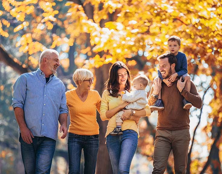 Family of three generations walking on a beautiful autumn day